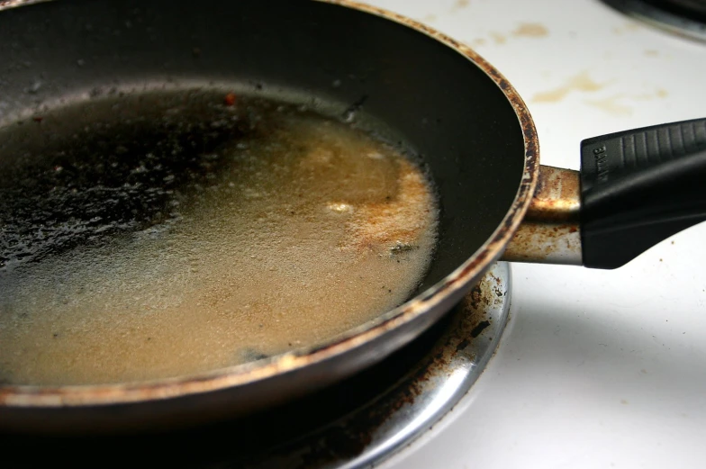 a large metal pot on the stove is filled with oil