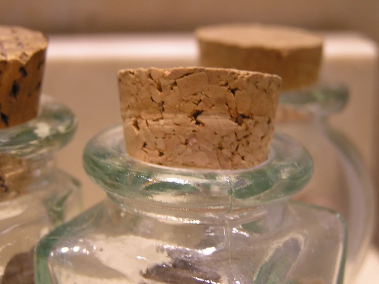 two glass jars with corked caps one is empty