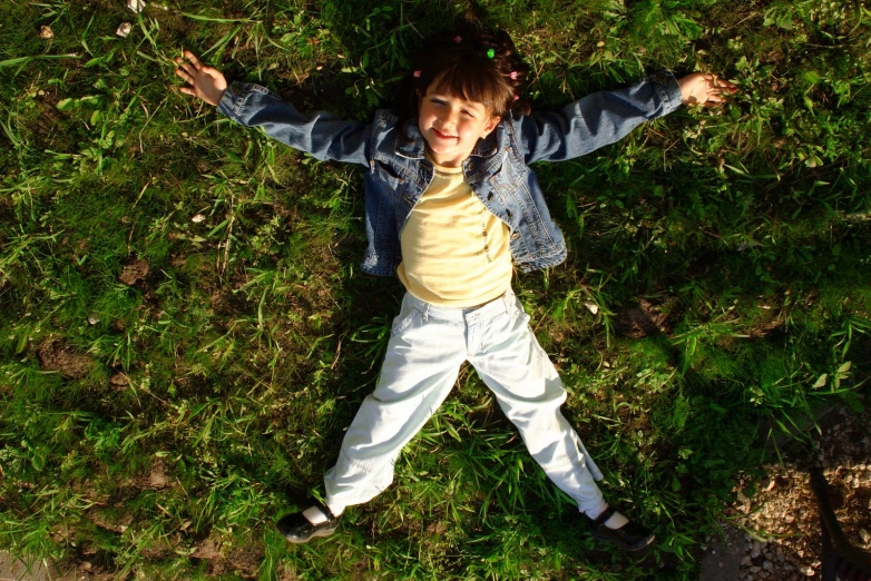 a child is laying down in a field