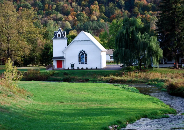 a church sitting on top of a grass covered field