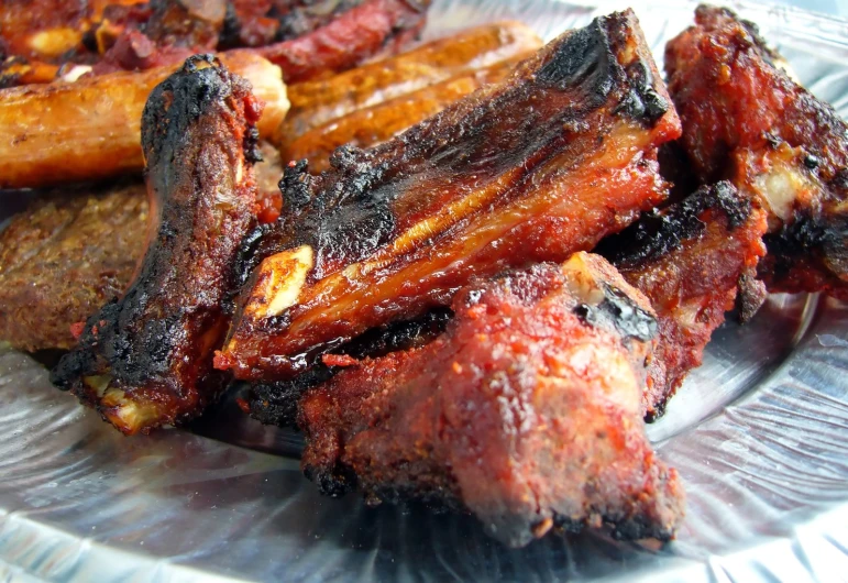 some cooked ribs are on a glass plate