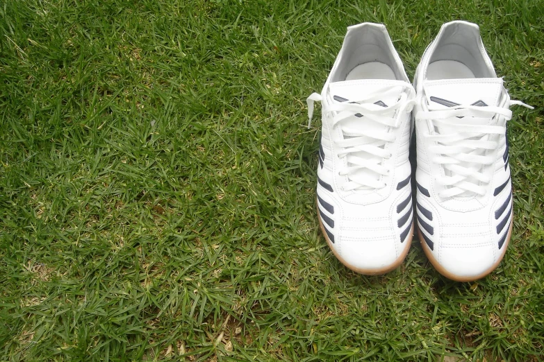 a pair of white shoes sitting on the grass