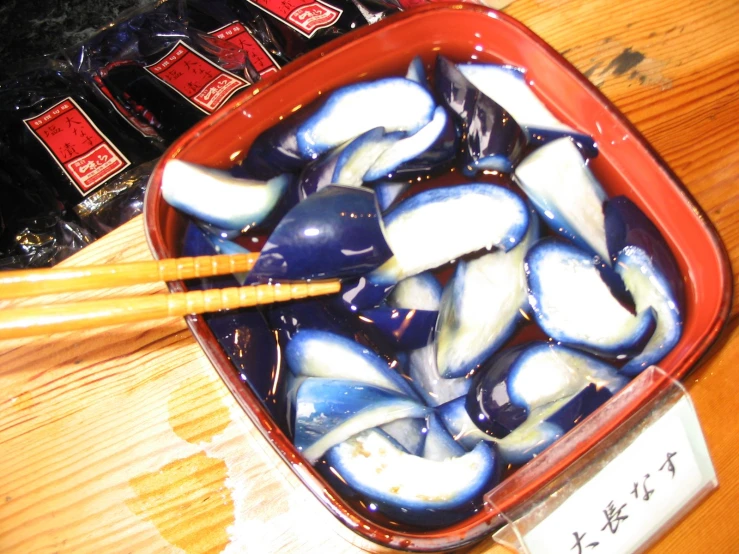 chopsticks with small white fish placed on top of the table