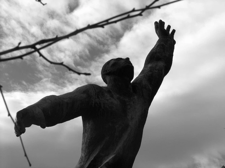 statue in front of cloudy sky near nches