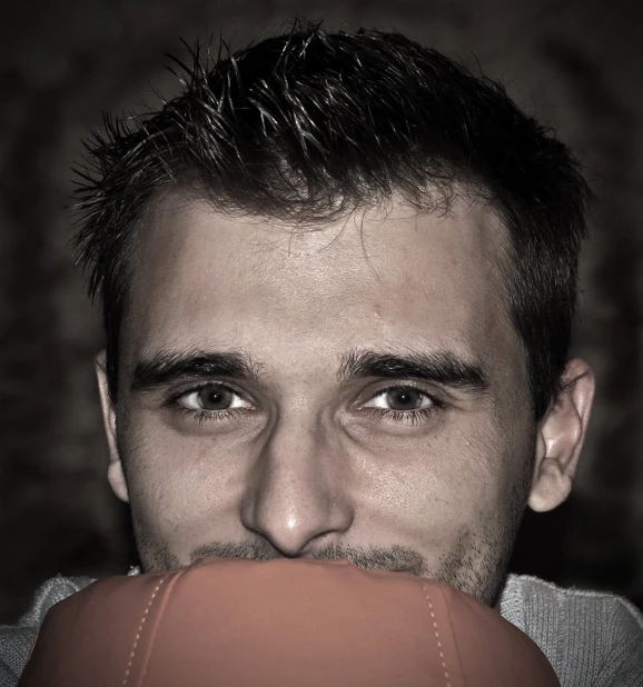 man looking over his mouth with football in his mouth