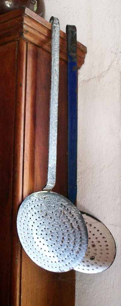 an old wooden coat rack with two irons