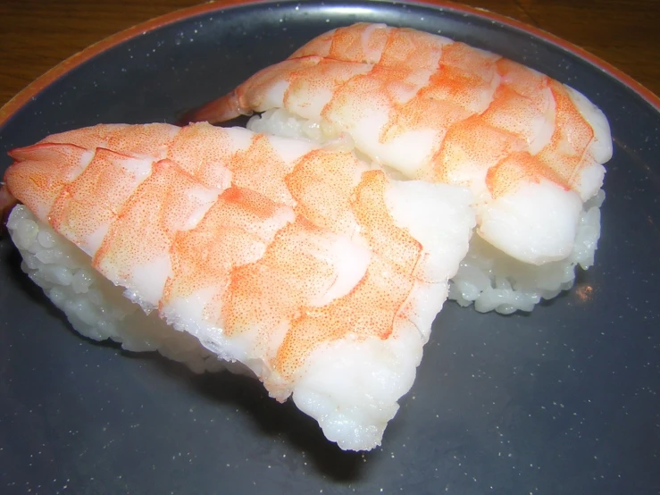two pieces of sushi sit on top of each other