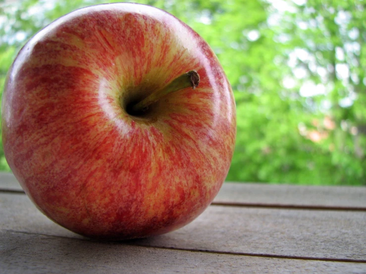 an apple sits on top of a wooden table