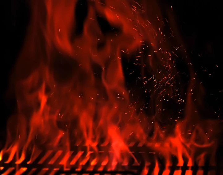 fire flames in the dark behind the grill