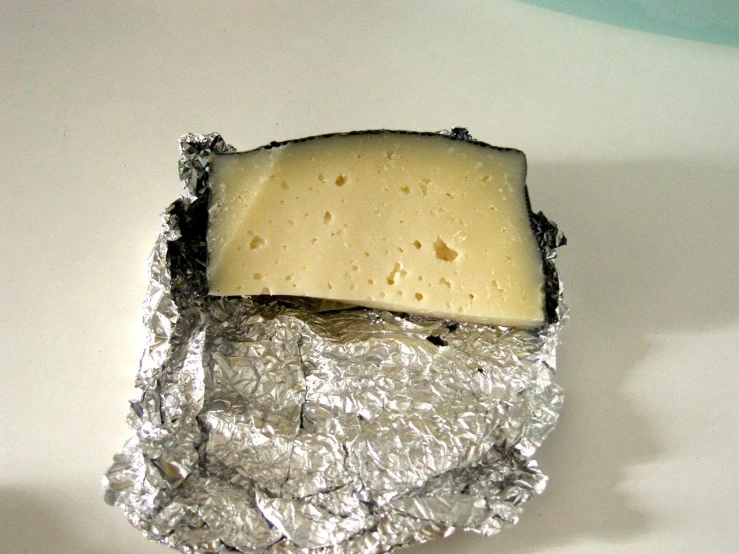 a piece of cheese sitting on top of tin foil