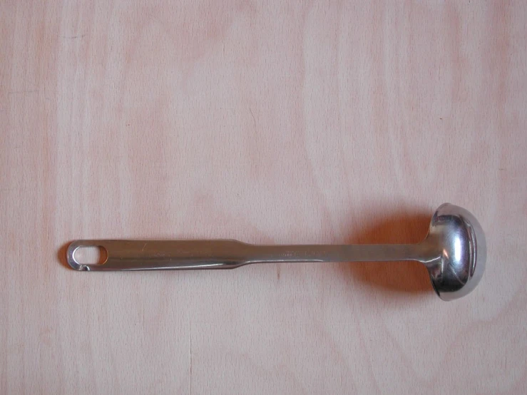 a metal spoon is attached to a wooden board