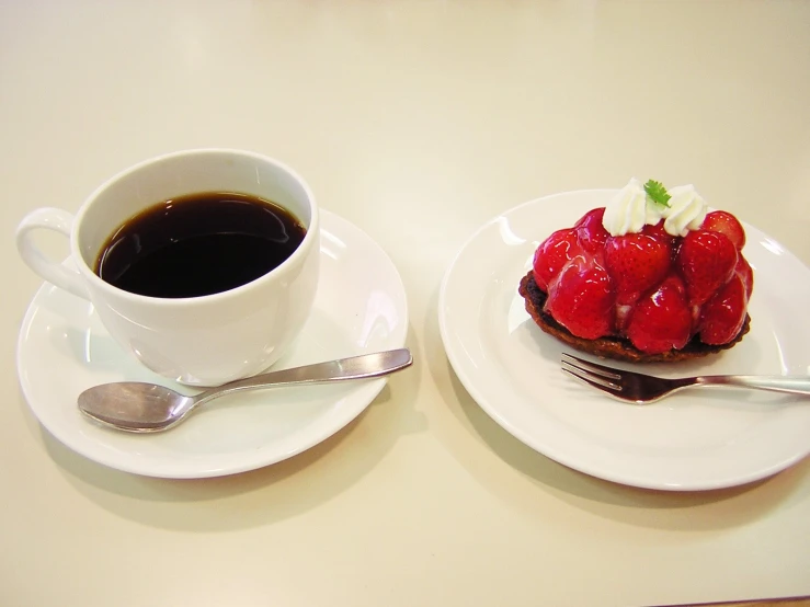 a couple plates on a table with fruit and coffee