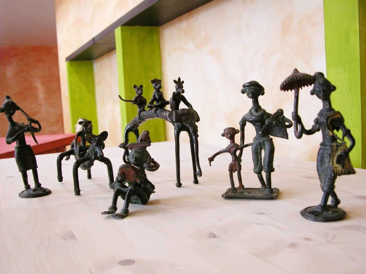 several bronze figurines with some of them holding knives and a sword