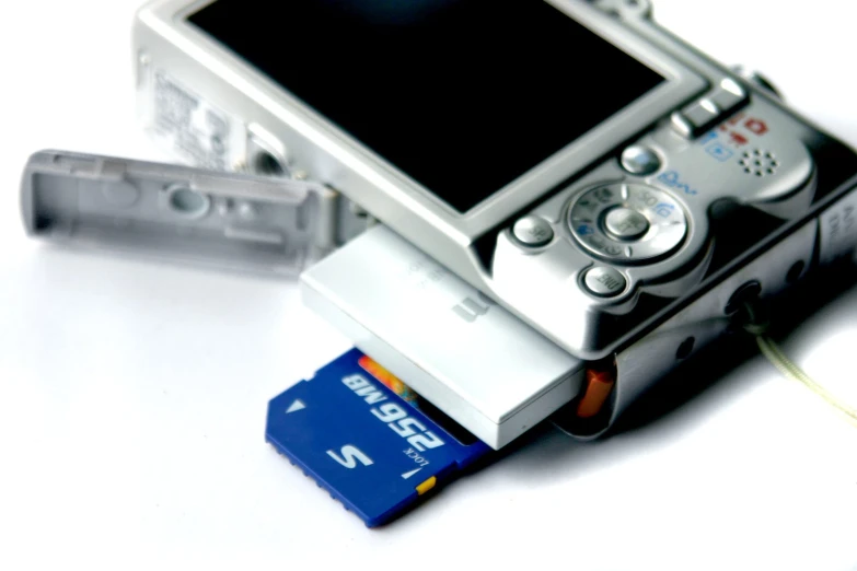 an electronic device on a table with a credit card and a camera
