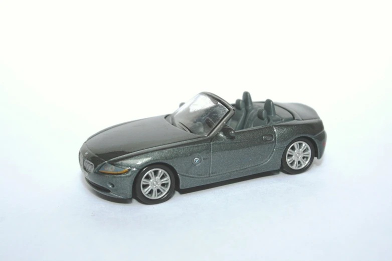 grey toy car with open top on white surface