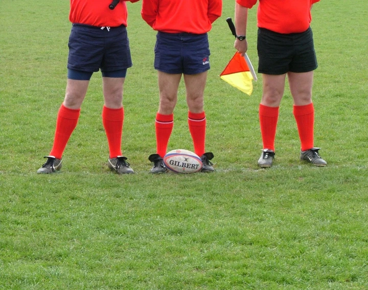 four men standing next to each other near a soccer ball