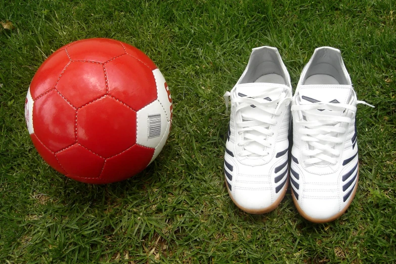 soccer ball and white sneakers sitting in the grass