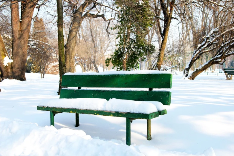 a park bench is covered in snow in the winter