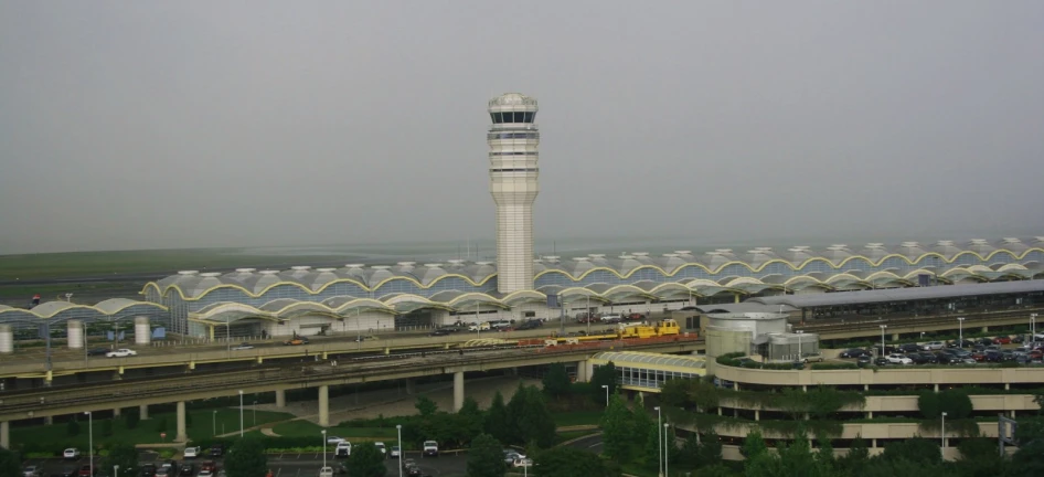 an airport with a train pulling into the terminal