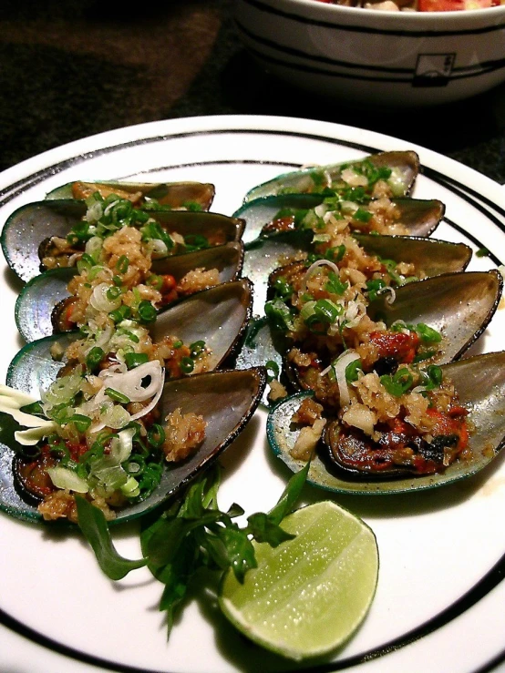 a white plate topped with sliced mussels and a fork