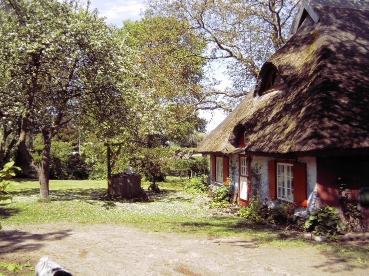 a woman is walking by an old, rustic red house