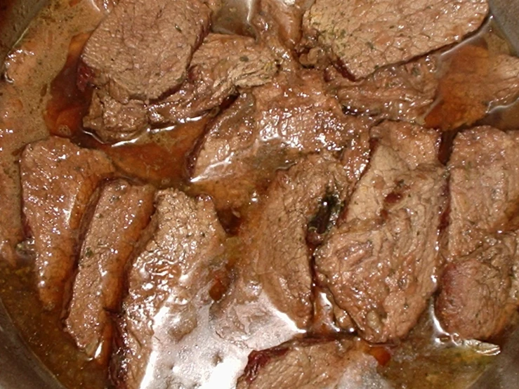 a pan with beef roast and seasonings in it