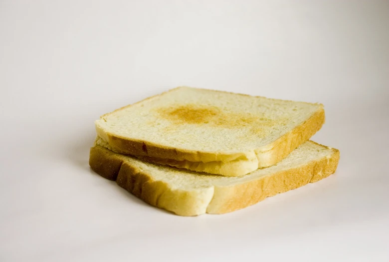 two slices of bread sit on a white surface