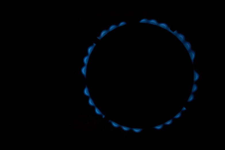 a gas stove is glowing dark with blue flames