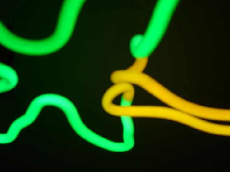 neon yellow and green light being stirred through a dark room