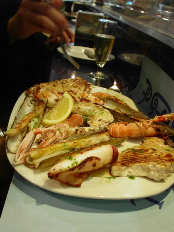 a seafood platter with grilled shrimp, scallions and lemons