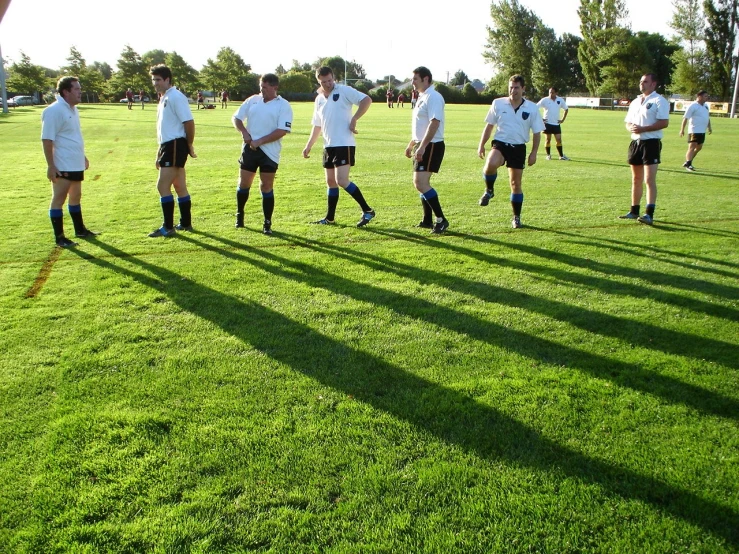 men are standing in their shorts on the field