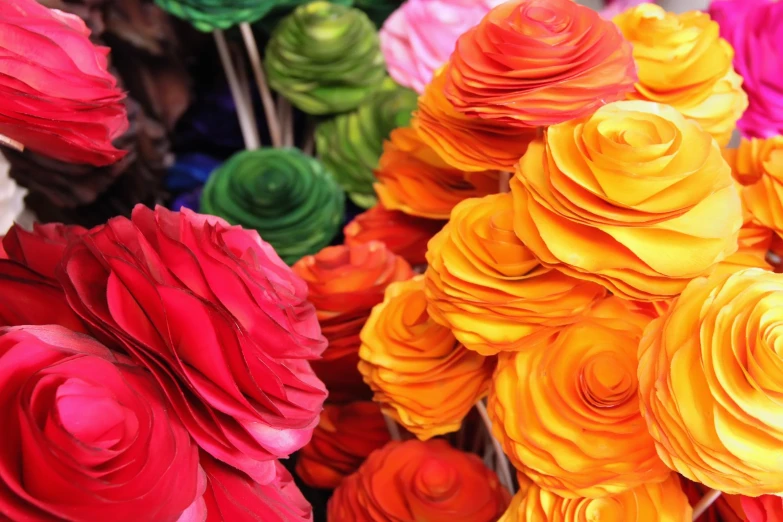 many different colored paper flowers sitting on display