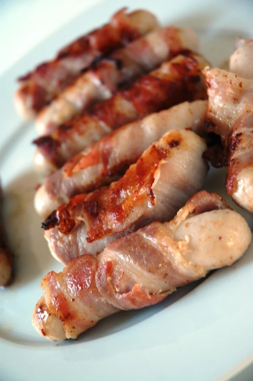 sliced bacon strips are being grilled on a plate