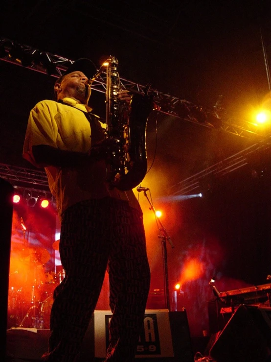 a man standing on top of a stage holding a trombone
