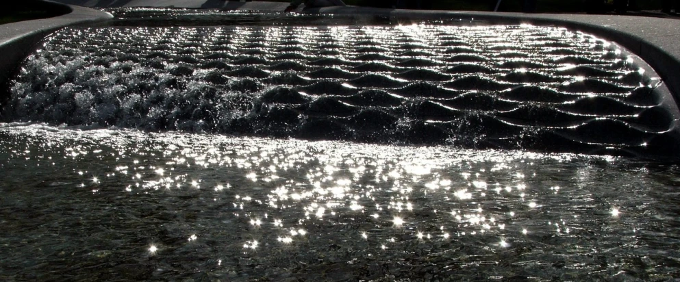 an icy pond with sun reflecting on the surface