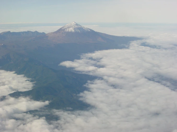 the view from a plane of some snow - covered mountains