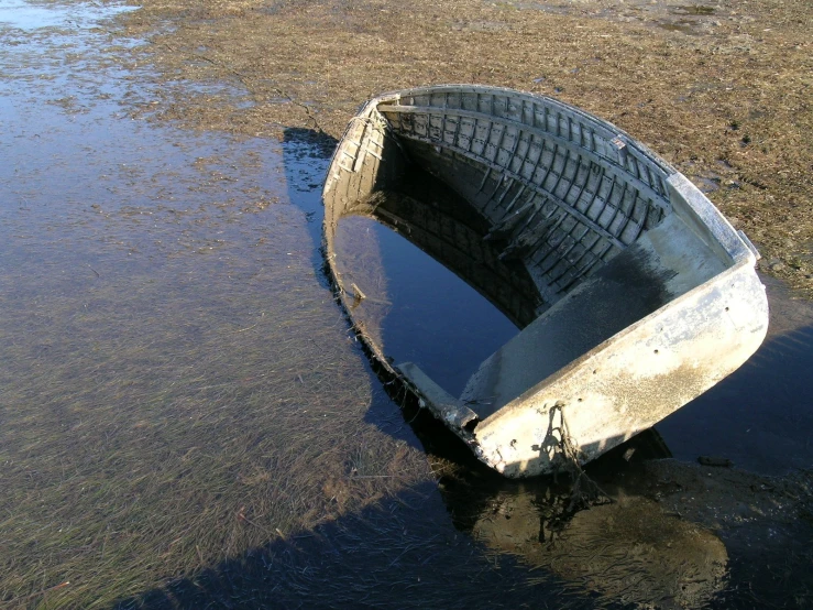 an old boat is lying in the middle of a lake