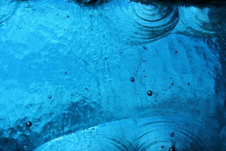 droplets of water and air on a blue glass surface