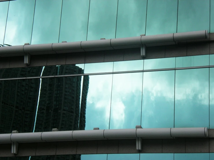 a building reflecting the sky behind some glass