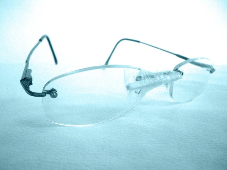 pair of eyeglasses with clear plastic frame on a light blue background