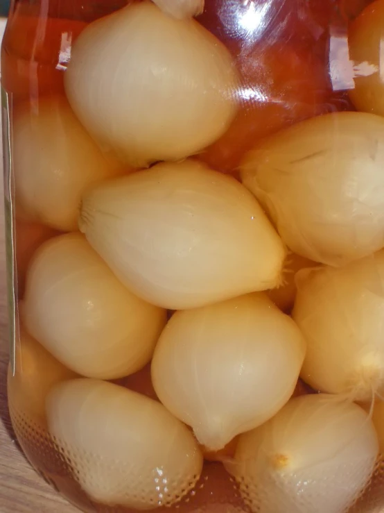 a clear jar filled with vegetables on a table