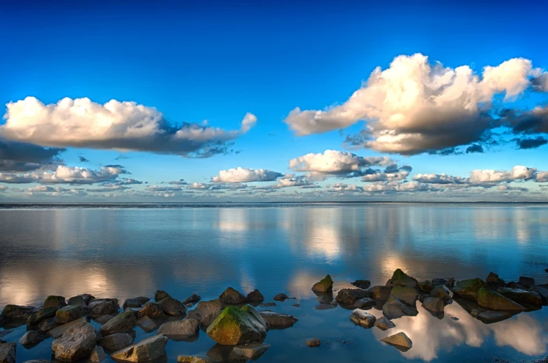 clouds and rocks in the water with sky reflection