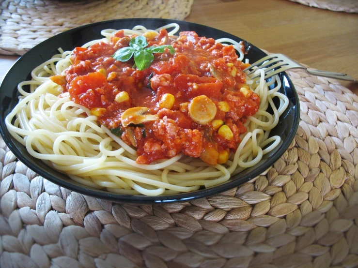 a bowl of spaghetti with tomato sauce and corn