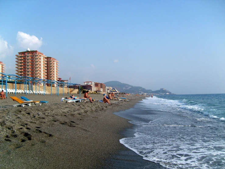 people are relaxing and walking on the beach