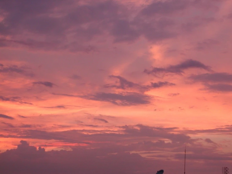 a red sky at dusk with the clouds in pink and blue