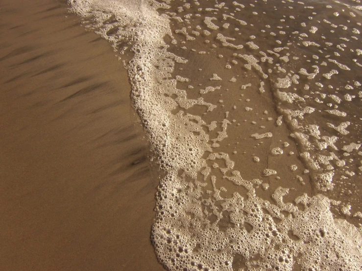 an image of the sand and waves on a beach