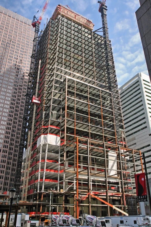 a large building under construction with several cranes around it