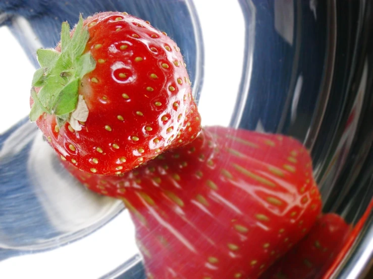 a strawberry is placed next to the fork