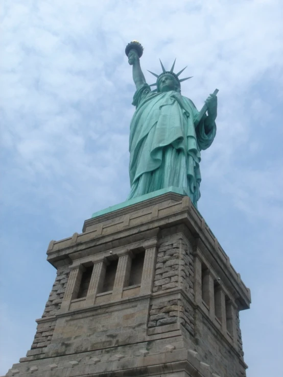 the statue of liberty is tall in the clouds