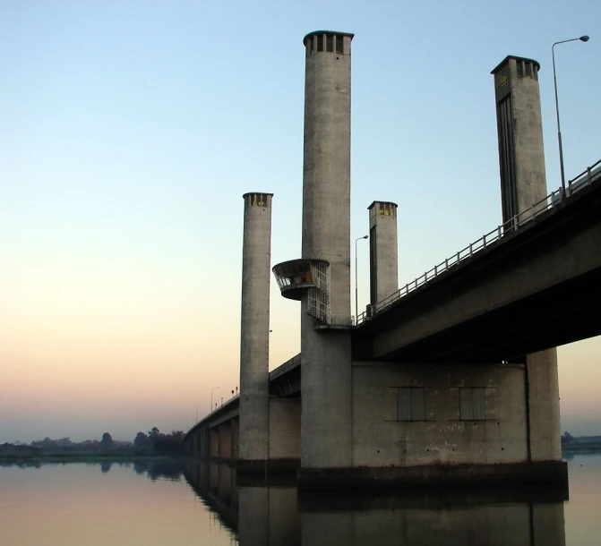 two power towers are seen standing on the edge of a river